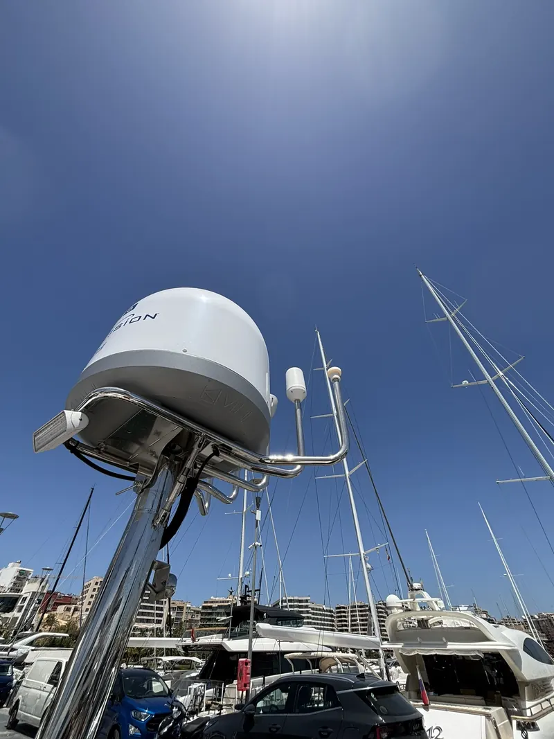 Domo de satélite marino montado en el mástil de un yate en un puerto de Mallorca